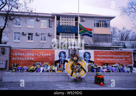 Des bouquets et des couronnes sont alignés en face de bannières avec des photos de l'ancien Président sud-africain Nelson Mandela et son dire à l'Afrique du Sud Banque D'Images