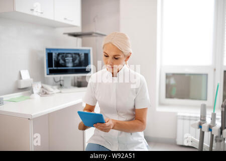 Dentiste Vérification de la date de son rendez-vous avec le patient. Banque D'Images