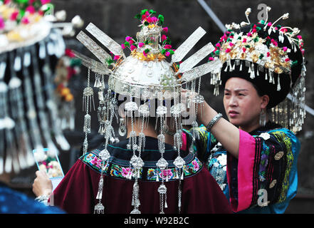 Les femmes chinoises de minorités ethniques Miao Miao vêtus de costumes traditionnels de régler leurs vêtements avant la cérémonie de clôture d'un festival culturel sur Banque D'Images