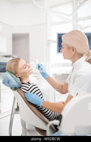 Young woman smiling pendant son traitement dentaire. Banque D'Images