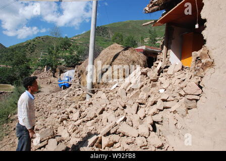 Un villageois se penche sur les débris de maisons dévastées par le tremblement de terre de magnitude 6,6 dans le comté de Minxian Majiagou, village, ville de Dingxi, au nord-ouest Banque D'Images