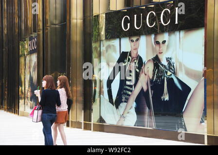 --FILE--les jeunes femmes à la mode chinoise devant une boutique de mode de Gucci à Nanning city, en Chine région autonome Zhuang du Guangxi, 1 avril 2012. Banque D'Images