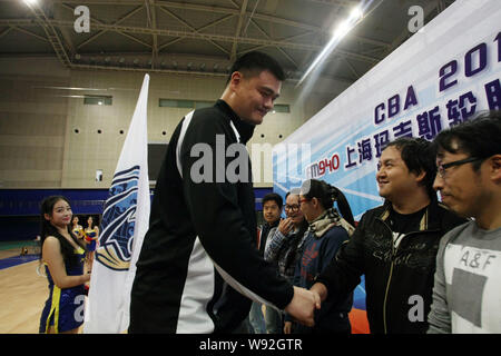 Ancien joueur de basket-ball NBA Yao Ming, centre, serre la main de fans chinois au cours d'une cérémonie à Shanghai les requins, un club de basket-ball, de Chines prép Banque D'Images