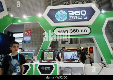 --FILE--un employé chinois passe devant le stand de l'AMJ 360.cn de Qihoo durant la 11e China Digital Entertainment Expo et conférence, connu sous le nom de Chine Banque D'Images