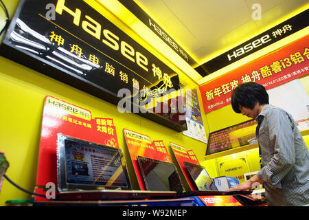 --FILE--un client chinois essaie de Hasee laptop ordinateurs à un magasin d'appareils électroménagers à Shanghai, Chine, 24 mars 2011. La Chine a dépassé les États-Unis Banque D'Images