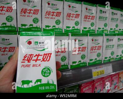 --FILE--qu'un client achète des boîtes de lait pur Mengniu dans un supermarché de Yichang, Chine centrale de la province du Hubei, le 8 janvier 2012. China Mengniu Dairy C Banque D'Images