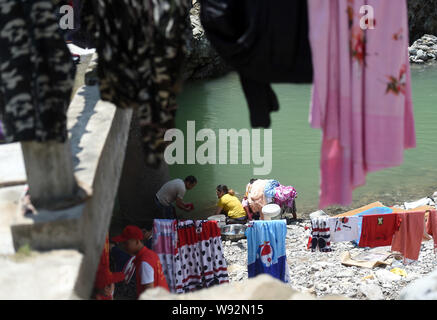 Yongjia, la Province de Zhejiang. Août 12, 2019. Lavez les vêtements des villageois et des feuilles qui ont été trempés par les inondations à côté d'un ruisseau dans Shanzao Village de Yantan Township dans Yongjia County, Zhejiang Province de Chine orientale, le 12 août 2019. Par lundi matin, le nombre de morts dans la province de Zhejiang a augmenté de 39 tandis que les neuf autres sont encore portés disparus, a déclaré que le contrôle des inondations de la province de Zhejiang siège. Le typhon Lekima, le neuvième et le plus puissant typhon de l'année, s'est posé autour de 1:45 h samedi de la ville de Wenling dans la province de Zhejiang. Han Crédit : Chuanhao/Xinhua/Alamy Live News Banque D'Images