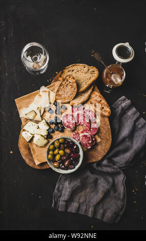 Vin blanc et snack sur fond noir, vue du dessus Banque D'Images