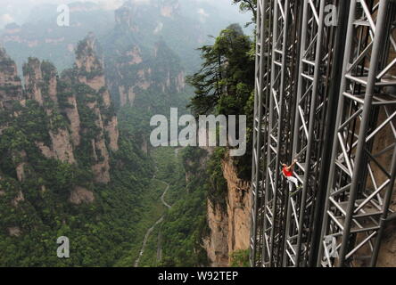 Alpiniste français Jean-Michel Casanova monte l'Ascenseur Bailong, également connu sous le nom de centaines de dragons, de l'élévateur dans Zhangjiajie scenic spot dans le centre de Chi Banque D'Images