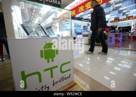 --FILE--un client chinois passe devant le comptoir de smartphone HTC à un marché de la téléphonie mobile à Shanghai, Chine, le 9 janvier 2013. Smartphon taïwanais Banque D'Images