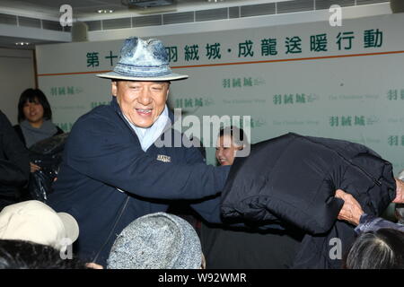 Hong Kong film super star Jackie Chan propose des vêtements en coton et le bas pour les personnes âgées lors d'un événement de bienfaisance à Hong Kong, Chine, 2 janvier 2013. Banque D'Images