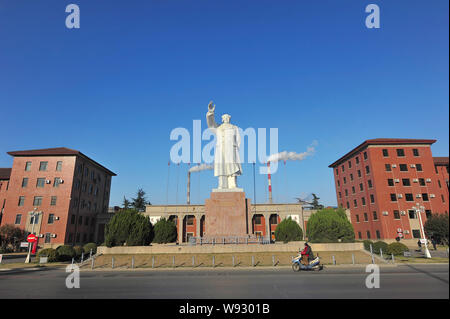 --FILE--un cycliste rides passé une statue de l'ancien leader chinois Mao Zedong en face de YTO Group Corporation à Luoyang city, Henan Chine centrale prov Banque D'Images