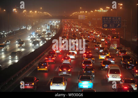 Masses de véhicules se déplacent lentement dans un embouteillage dans le smog lourde à Beijing, Chine, 2 novembre 2013. Beijing est d'être obligés d'examiner la restrictio Banque D'Images