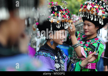 Les femmes chinoises de minorités ethniques Miao Miao vêtus de costumes traditionnels de régler leurs vêtements avant la cérémonie de clôture d'un festival culturel sur Banque D'Images