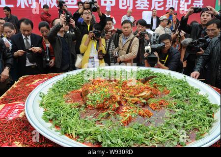 Les journalistes et les visiteurs de prendre des photos et vidéos d'un gigantesque plat de poisson cuit à la vapeur avec les dés de poivrons au cours de la 23e Chef Chinois Festival à C Banque D'Images