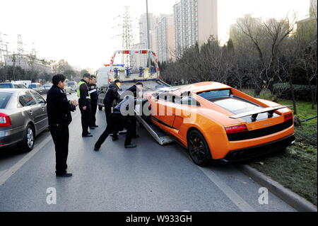 --FILE--une voiture de sport Lamborghini endommagé est tiré sur un camion de remorquage après il s'écrasa dans un garde-corps sur une route dans la ville de Xian, dans les Chines S Banque D'Images