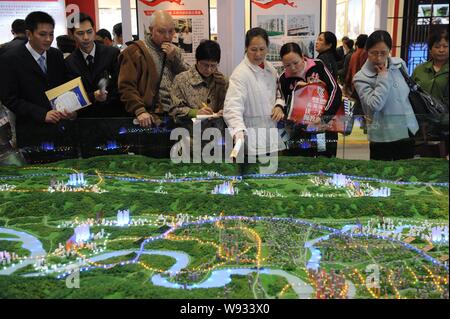 --FILE--acheteurs potentiels regarder une maquette d'un nouveau développement du logement pendant une propriété juste à Chongqing, Chine 15 avril 2010. Cdm moyenne Banque D'Images