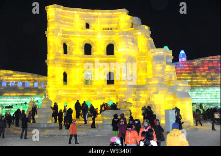 Les visiteurs passent devant les sculptures de glace à la 15e Harbin Ice and Snow World in Harbin City, au nord-est de la province chinoise, le 29 décembre 2013. E Banque D'Images