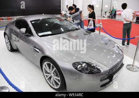 --FILE--visiteurs regarder une Aston Martin V8 Vantage pendant un auto show de Wuhan, Chine centrale la province du Hubei, 25 mai 2013. Aston Martin a Banque D'Images