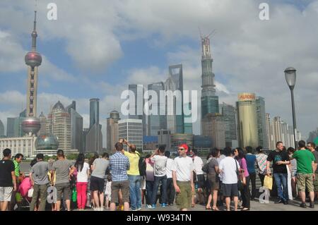 --FILE--affaires de touristes visitent la promenade du Bund à l'encontre de l'horizon de la financier de Lujiazui avec l'Oriental Pearl TV Tower, gauche Banque D'Images