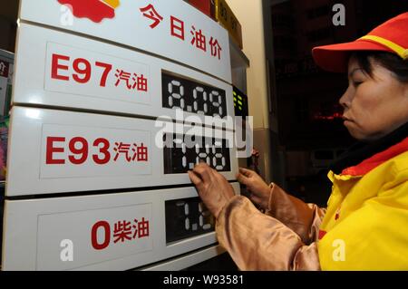 Un travailleur chinois met à jour le prix du carburant après minuit dans une station de la CNPC (China National Petroleum Corporation), société mère de PetroChina, à Luoyang Banque D'Images