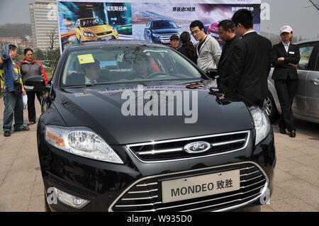 --FILE--visiteurs chinois d'essayer et d'examiner une Ford Mondeo lors d'une auto show de la ville de Qingdao, Chine de l'est la province de Shandong, 22 avril 2012. FORD M Banque D'Images