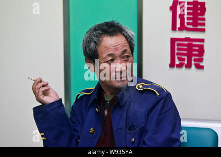 --FILE--un Chinois fume une cigarette à une station de bus longue distance à Qingdao, Chine de l'est la province de Shandong, le 30 mai 2013. Anti-tabac chines Banque D'Images