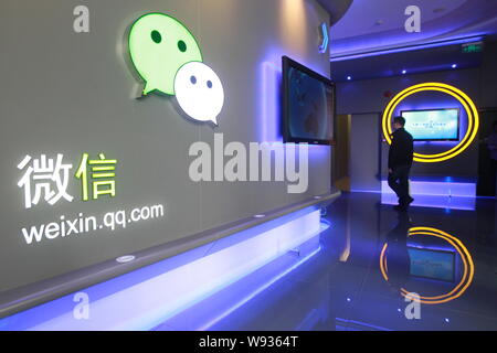 --FILE--un employé chinois passe devant une signalisation de la messagerie mobile app Weixin, ou de Tencent WeChat au siège de Tencent à Shenzhen, dans le sud Banque D'Images