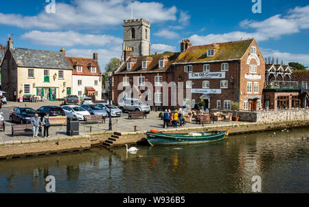 Wareham, England, UK - 27 mars 2019 : les gens marchent le long des quais de la rivière Frome à côté de l'ancienne maisons et bâtiments de Wareham dans Banque D'Images