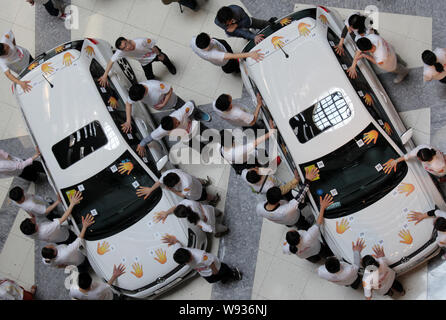 Les concurrents chinois garder leurs mains sur les voitures Volkswagen Polo GTI pendant une main-sur-compétition d'endurance voiture de Super Brand Mall dans le Lujiazui Financ Banque D'Images