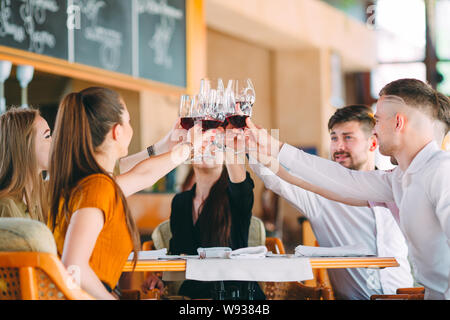 Les amis de prendre un verre de vin sur la terrasse du restaurant. Banque D'Images