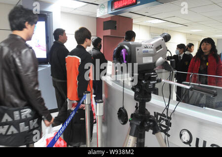 Un détecteur de rayons infrarouges vérifie la température du corps des passagers à l'Aéroport International de Taiwan Taoyuan à Taipei, Taiwan, 1 avril 2013. L'expérience de la santé Banque D'Images