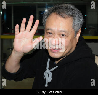 Le réalisateur taïwanais Ang Lee waves après son arrivée à l'Aéroport International de Taiwan Taoyuan à Taipei, Taiwan, 11 novembre 2013. Banque D'Images