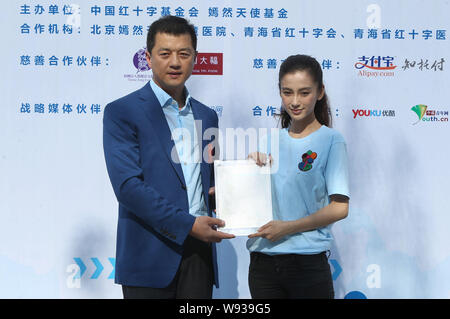 L'acteur chinois Li Yapeng, à gauche, et l'actrice de Hong Kong Angelababy détient un certificat au cours d'un évènement promotionnel pour le sourire Angel Foundation à Pékin Banque D'Images