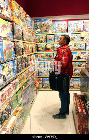 Boutique de jouets. Magasin de jouets. À l'intérieur de magasin de jouets. Lignes d'étagères avec des jouets. La joie des enfants. Man toy entre grande sélection dans la boutique. Boutique pour Banque D'Images