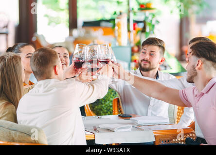 Les amis de prendre un verre de vin sur la terrasse du restaurant. Banque D'Images