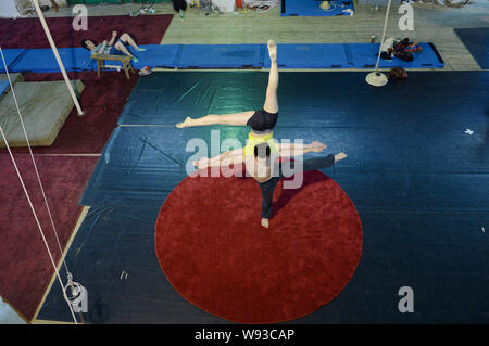 Les jeunes acrobates chinois pratique au centre de formation de la troupe acrobatique de soldat du Département politique de la région militaire de Guangzhou en Gua Banque D'Images