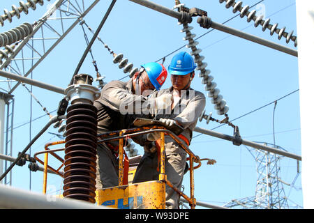 Les électriciens chinois de la State Grid Corporation of China vérifier et réparer les appareils électriques à un poste de transformation Yichang city, le centre de Menton Banque D'Images
