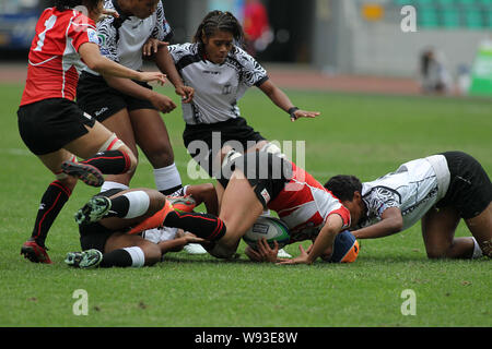 Les joueurs du Japon (rouge) et les Fidji (blanc) lors de leur match au cours de l'IRB Sevens 2013 Womens World Series dans la ville de Guangzhou, Chine du sud Guangdon Banque D'Images