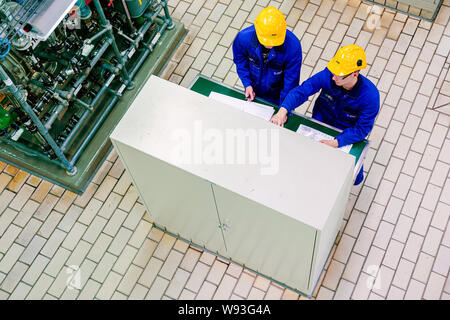 Ludwigshafen, Allemagne. Août 12, 2019. Les stagiaires, vêtus de costumes bleus et jaunes construction worker casques, travailler dans un hall de production de l'entreprise chimique BASF. Ministre de l'emploi Heil est sur un voyage d'été. Credit : Uwe Anspach/dpa/Alamy Live News Banque D'Images