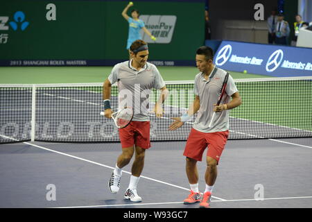 La Suisse de Roger Federer, à gauche, et Chines ZHANG Ze parler lors du premier tour dans le match de double du tournoi de tennis Masters de Shanghai Banque D'Images