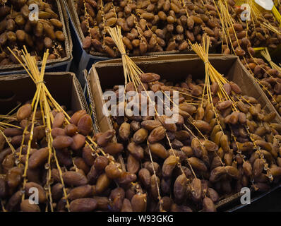 Dates fraîches sur les branches vendus sur le marché local en Tunisie Banque D'Images