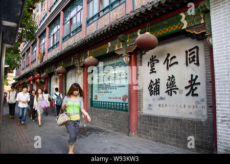 Les piétons passent devant une boutique de Tongrentang, une marque de la médecine traditionnelle chinoise depuis 1669, à Shanghai, Chine, 24 mai 2013. Traditio Banque D'Images