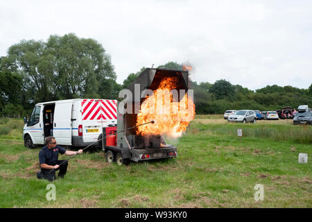 Démonstration Pompiers quant aux effets de verser de l'eau sur une puce feu d'huile du carter. Banque D'Images