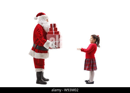 Tourné sur toute la longueur du Père Noël Donner une pile de cadeaux de Noël à une petite fille heureux isolé sur fond blanc Banque D'Images