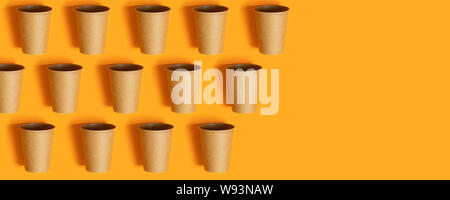 Tasses de papier sur fond orange avec copie espace. Un minimum de mise à plat Banque D'Images