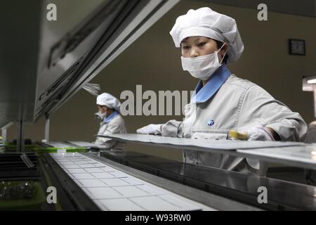 --FILE--femelle des travailleurs chinois produisent des panneaux solaires pour être exporté en Europe dans une usine de Wuxi city, province de Jiangsu, Chine de l'Est, 5 juin 2013 Banque D'Images