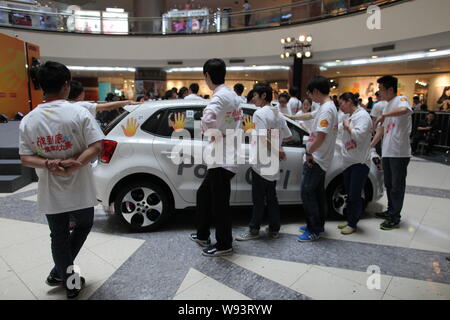 Les concurrents chinois garder leurs mains sur une Volkswagen Polo GTI pendant une main-sur-compétition d'endurance voiture de Super Brand Mall dans le quartier financier de Lujiazui Banque D'Images