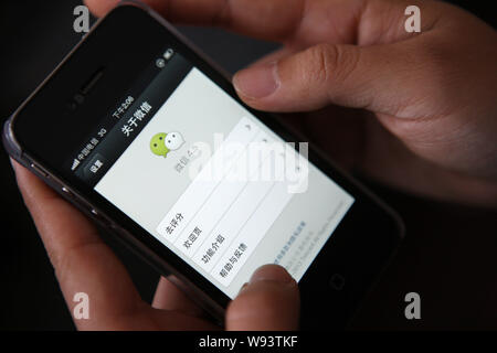 --FILE--Une femme chinoise utilise la messagerie mobile app Weixin, ou de Tencent WeChat, sur son Apple iPhone 4S smartphone dans Shanghai, Chine, le 7 avril 2013. Banque D'Images