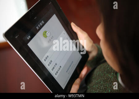 --FILE--Une femme chinoise utilise la messagerie mobile app Weixin, ou de Tencent WeChat, sur son Apple iPad tablet PC à Shanghai, Chine, le 7 avril 2013. Le rendez-vous Banque D'Images